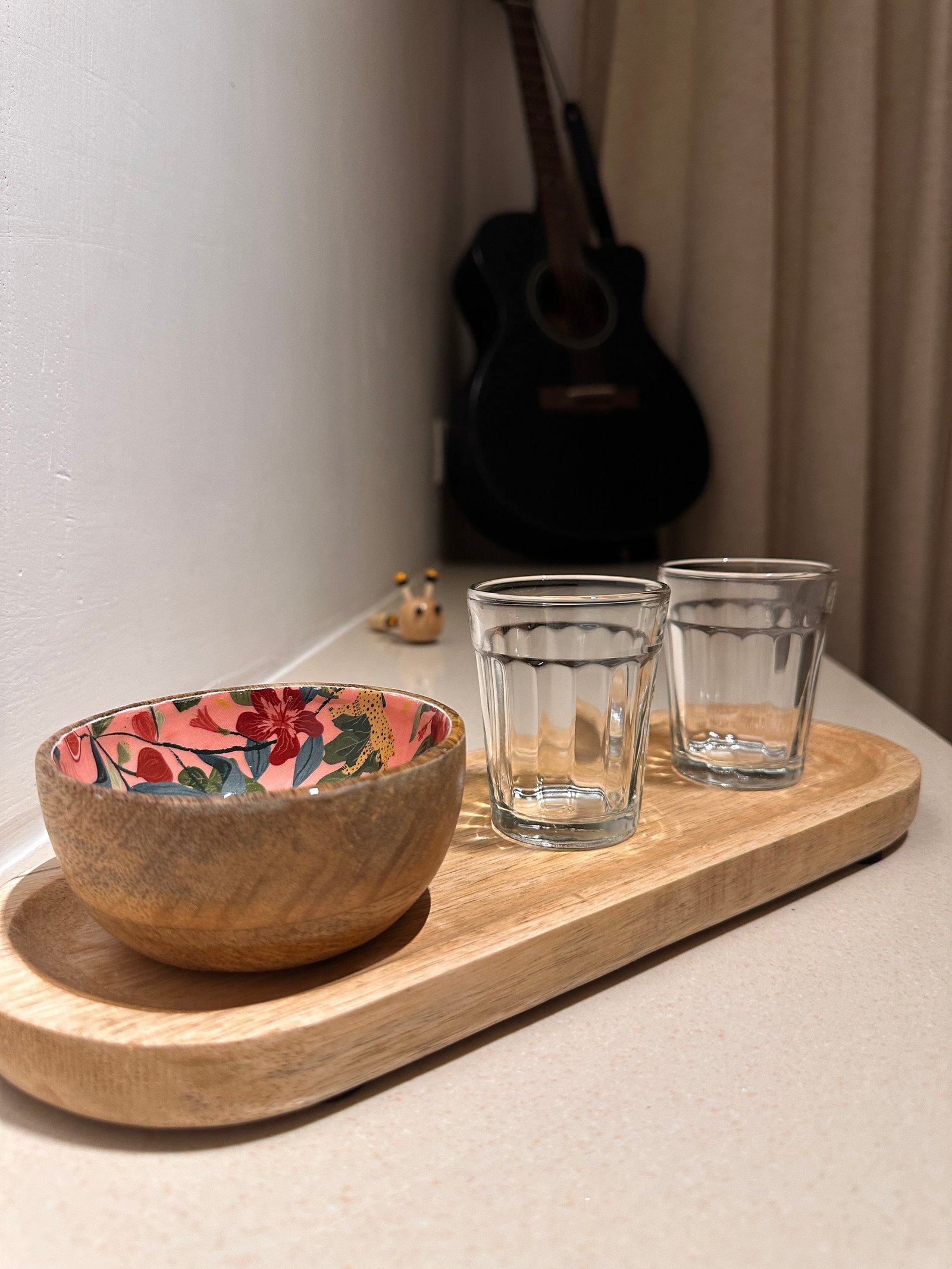 Espresso Sidecar 1 Two small fluted glasses and a floral-lined wooden bowl on a wooden serving tray, with a guitar in the background.